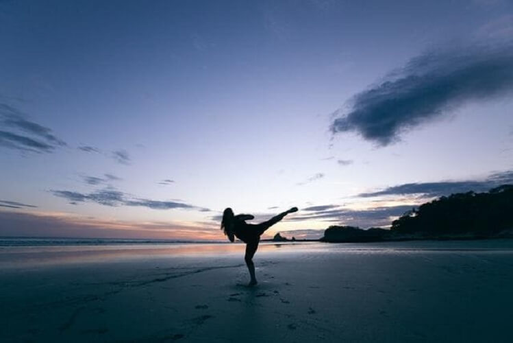 person doing karate on a beach